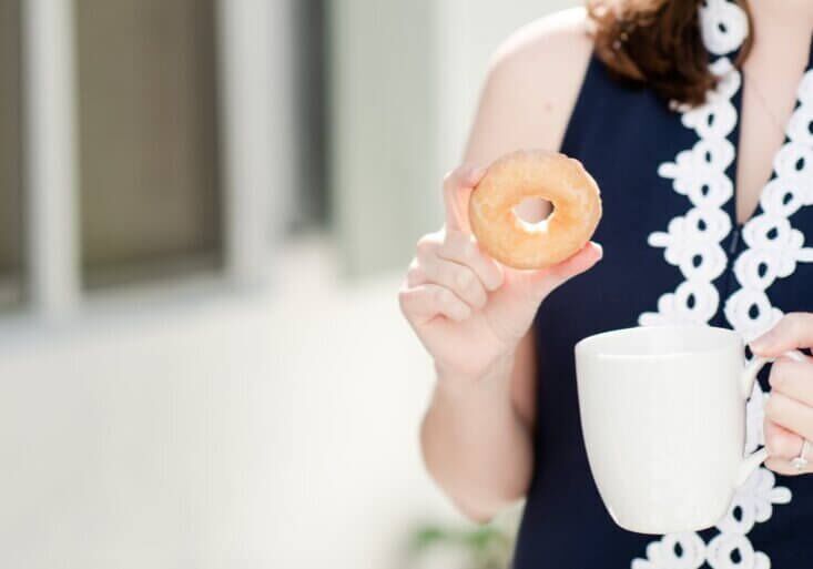 Lauren Scheffer, a food allergy travel agent holding a gluten free donut